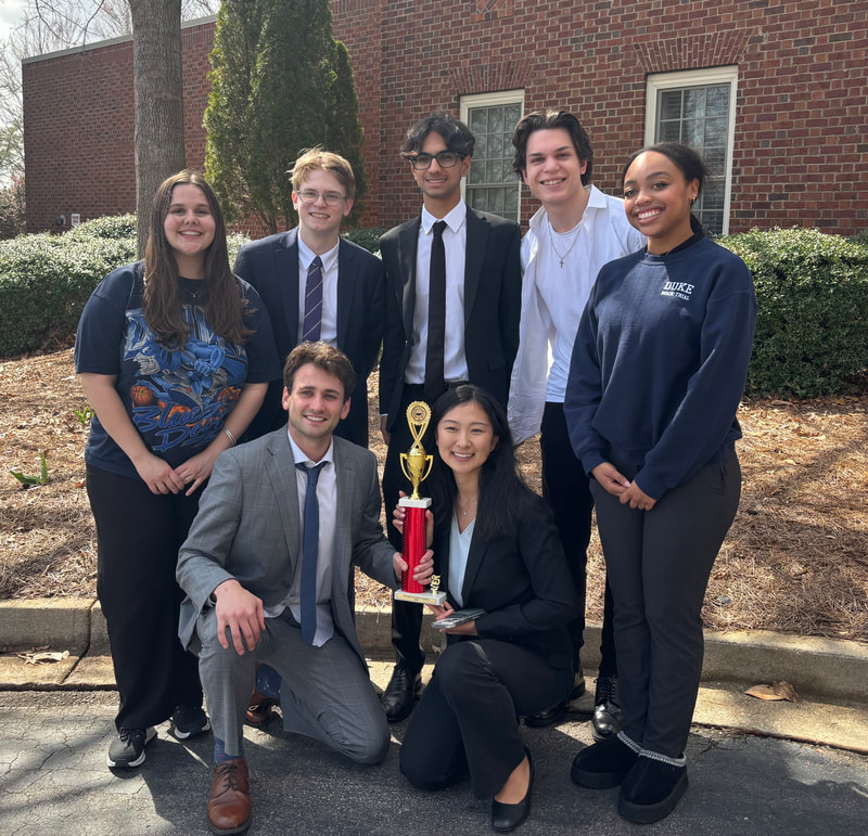 Duke Mock Trial holding a tournament trophy